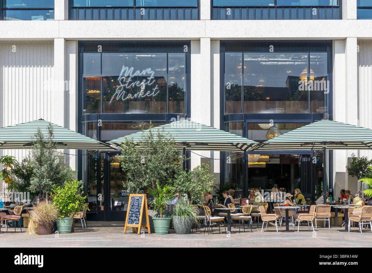 La gente sedeva fuori dal bar e ristorante Mare Street Market in Lewis Cubitt Square a King's Cross. Foto Stock