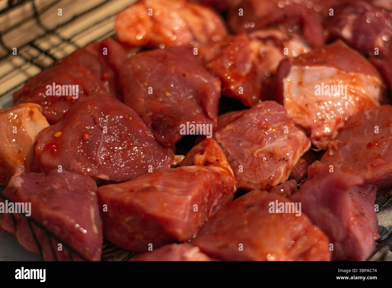I pezzi di carne marinata sono pronti per la cottura alla griglia, con colori e sapori ricchi che stuzzicano le papille gustative Foto Stock