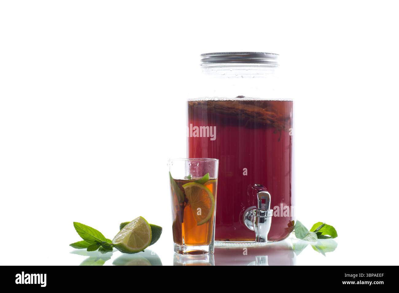 Kombucha rinfrescante in un vaso di vetro e un bicchiere con calce su sfondo bianco. Foto Stock Kombucha rinfrescante in un vaso di vetro e un bicchiere con calce su sfondo bianco. Foto Stock