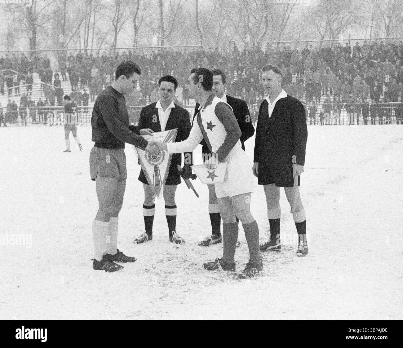 Anni sessanta, sport, calcio, amichevole, 26.12.1964, stadio Glueckaufkampfbahn a Gelsenkirchen, FC Schalke 04 vs. Slavia Praga 2-1, partita su neve, di fronte alla partita i capitani della squadra ufficiali scambiano i wimples del club, sinistra Manfred Kreuz (S04) Foto Stock