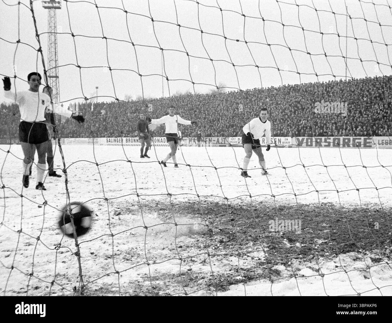 Sessant'anni, sport, calcio, Regionalliga West, 1965/1966, rot-Weiss Essen vs. Eintracht Duisburg 2-0, 16.01.1966, Stadium an der Hafenstrasse di Essen, vento, campo innevato, area goal, giocatori del Duisburg si prendono cura del pallone, nessun gol per Essen Foto Stock