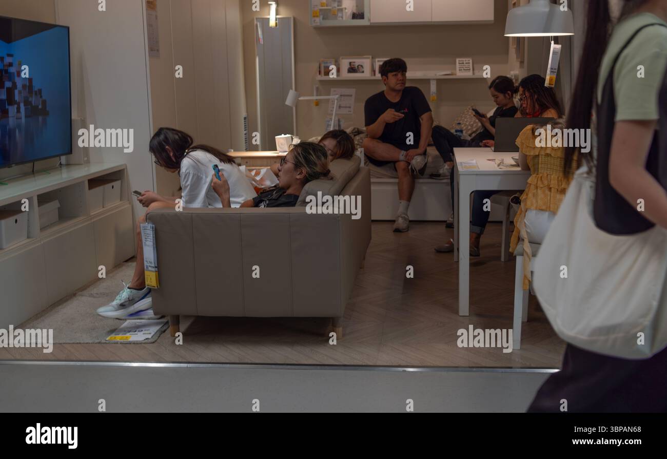 Hong Kong - 7 giugno 2025: Le persone a Hong Kong amano sedersi su mobili da esposizione nel negozio di mobili IKEA di Hong Kong. IKEA è un conglomer multinazionale Foto Stock