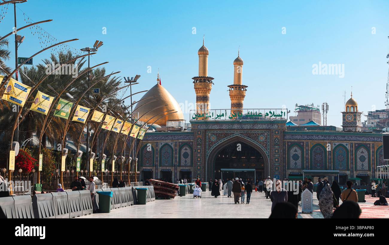La gente si riunisce al santuario dell'Imam Hussain a Karbala, Iraq, sperimentando l'atmosfera vibrante in una giornata di sole. Foto Stock