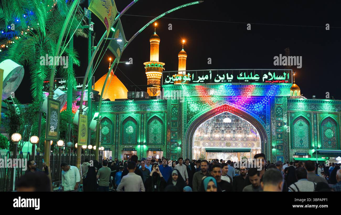 I visitatori di diverse origini si riuniscono pacificamente nel santuario illuminato dell'Imam Hussein a Karbala per un evento religioso. Foto Stock