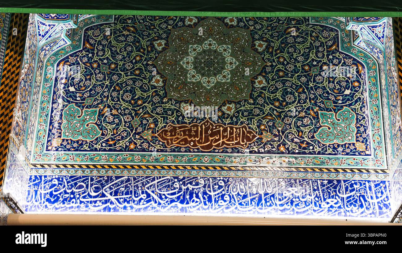 I visitatori ammirano le dettagliate piastrelle del santuario Imam Hussein a Karbala in Iraq durante un significativo evento religioso al tramonto. Foto Stock