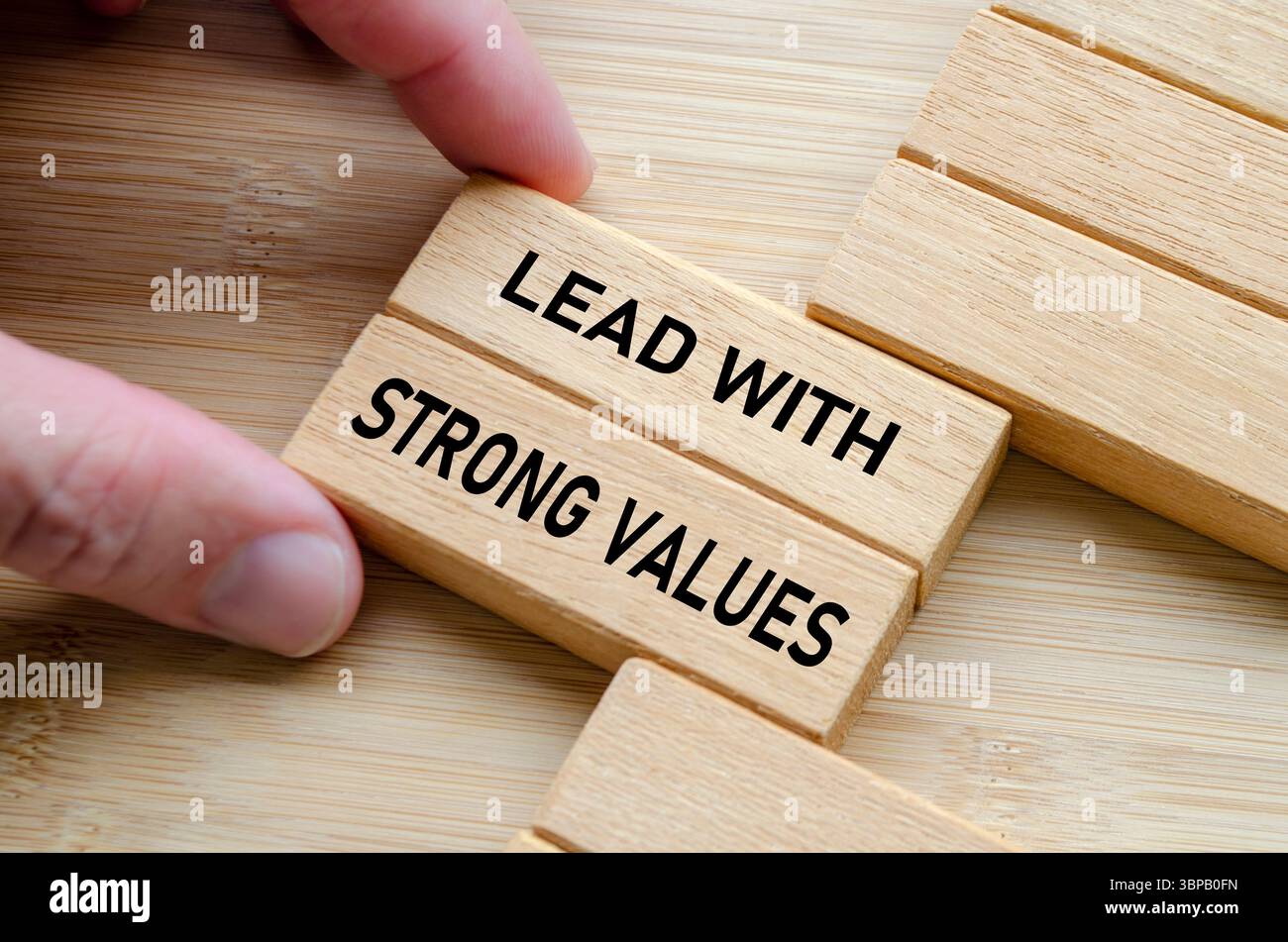 Guidare con una frase di valori forti su blocchi di legno impilati, sottolineando l'importanza dell'integrità, del coraggio e dell'etica nei ruoli di leadership. Foto Stock