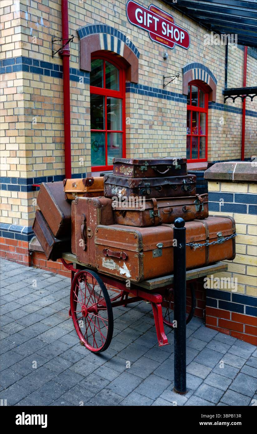 Valigie d'epoca su un carrello presso il negozio di articoli da regalo presso la stazione ferroviaria di Lakeside e Haverthwate, attrazione turistica di Windemere, Cumbria Foto Stock
