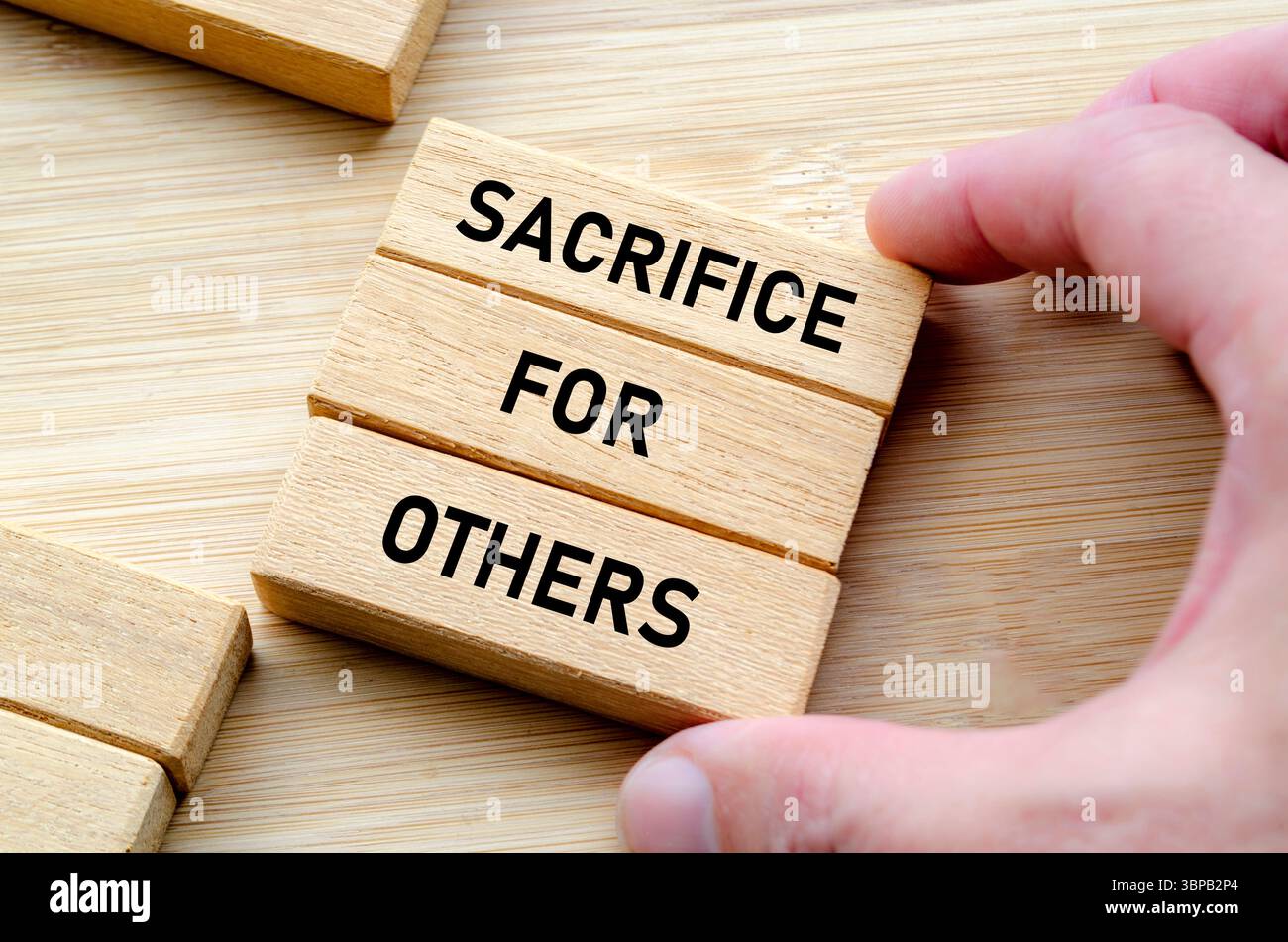 Sacrificio per gli altri frase su blocchi di legno, aspettative di leadership e concetto di rispetto. Foto Stock