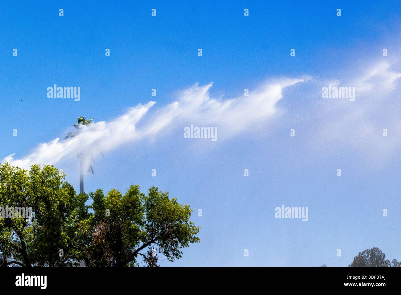 Il camion dei pompieri spruzza acqua sui bambini per divertirsi in estate al Parkview Park di Tucson, Arizona, una pausa fresca sotto il sole del deserto. Foto Stock