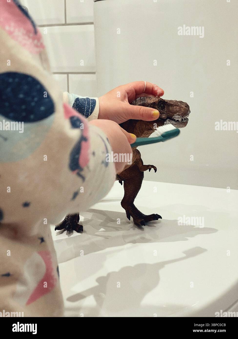 Bambini che spazzolano i denti del dinosauro giocattolo – divertimento igiene apprendimento per bambini Foto Stock
