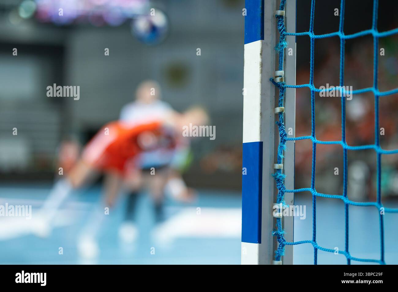 Dettagli della mano e del gioco di pallamano del portiere sullo sfondo. Foto Stock