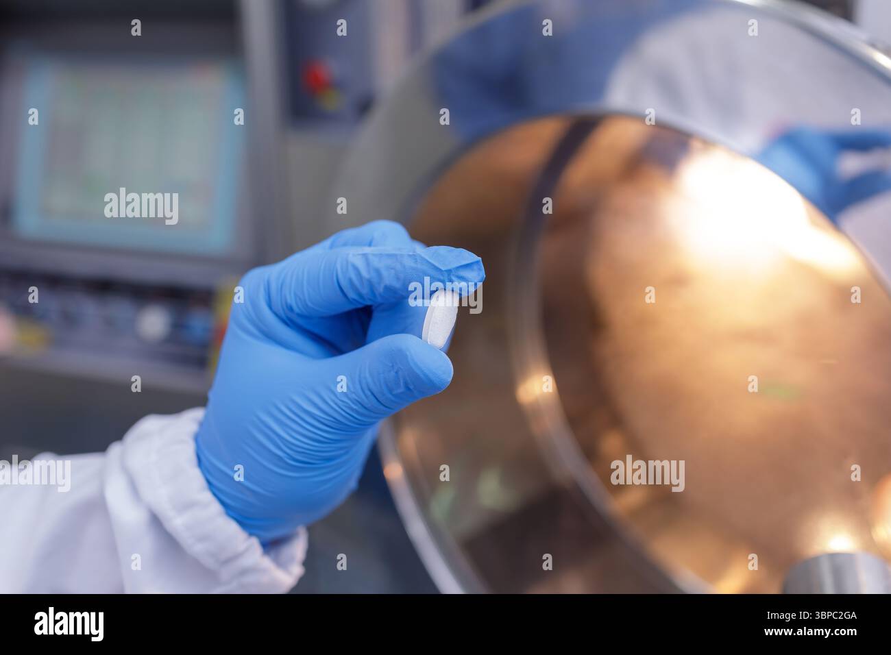 Il lavoratore con guanti ispeziona una singola pillola durante il controllo di qualità in un impianto di produzione farmaceutica sterile Foto Stock