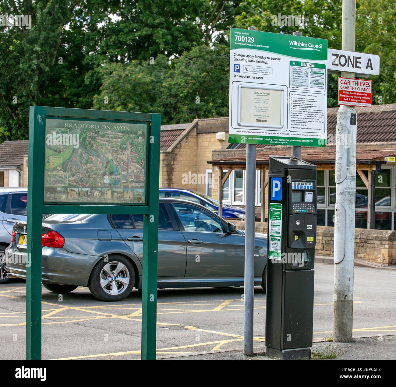 Un parcheggio a Bradford su Avon con cartelli che riportano le informazioni sul parcheggio e gli avvisi di sicurezza vicino alle auto parcheggiate Foto Stock