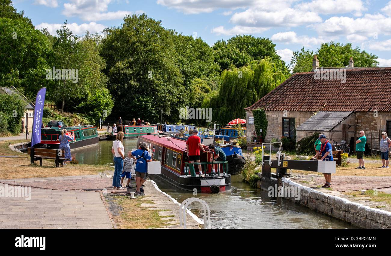 In una giornata di sole, le persone si riuniscono in giro per Bradford, all'uscita di un'imbarcazione stretta, sulla chiusa del canale Avon sul canale Kennet e Avon Foto Stock