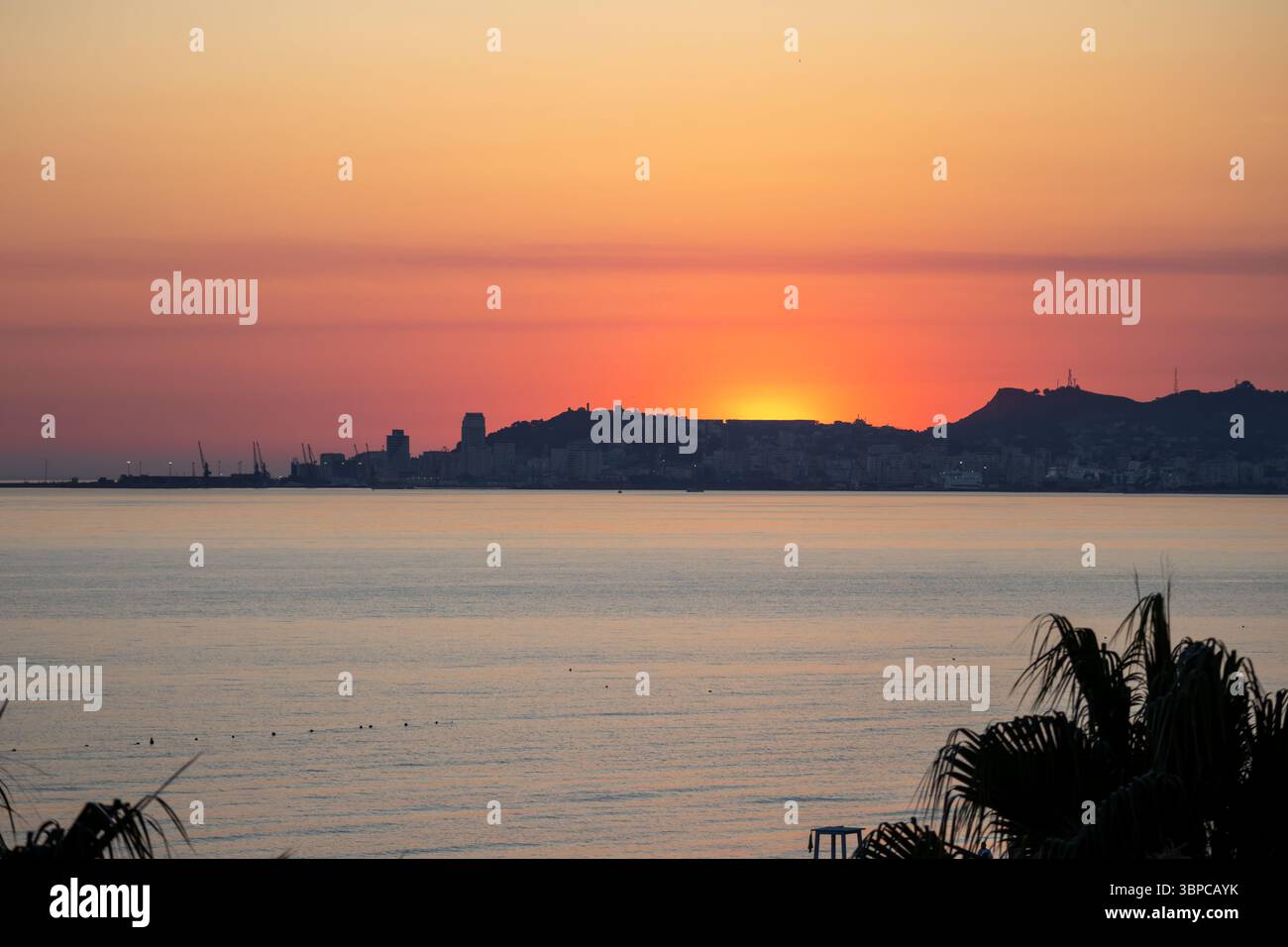 vivace tramonto sullo skyline della città costiera Foto Stock