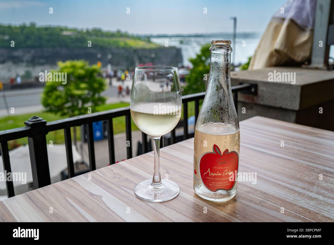 Una bottiglia di sidro di mele Viene e un bicchiere su un tavolo con vista sulle cascate del Niagara dal lato canadese. I prodotti AG sono inclusi nella questione commerciale degli Stati Uniti Foto Stock