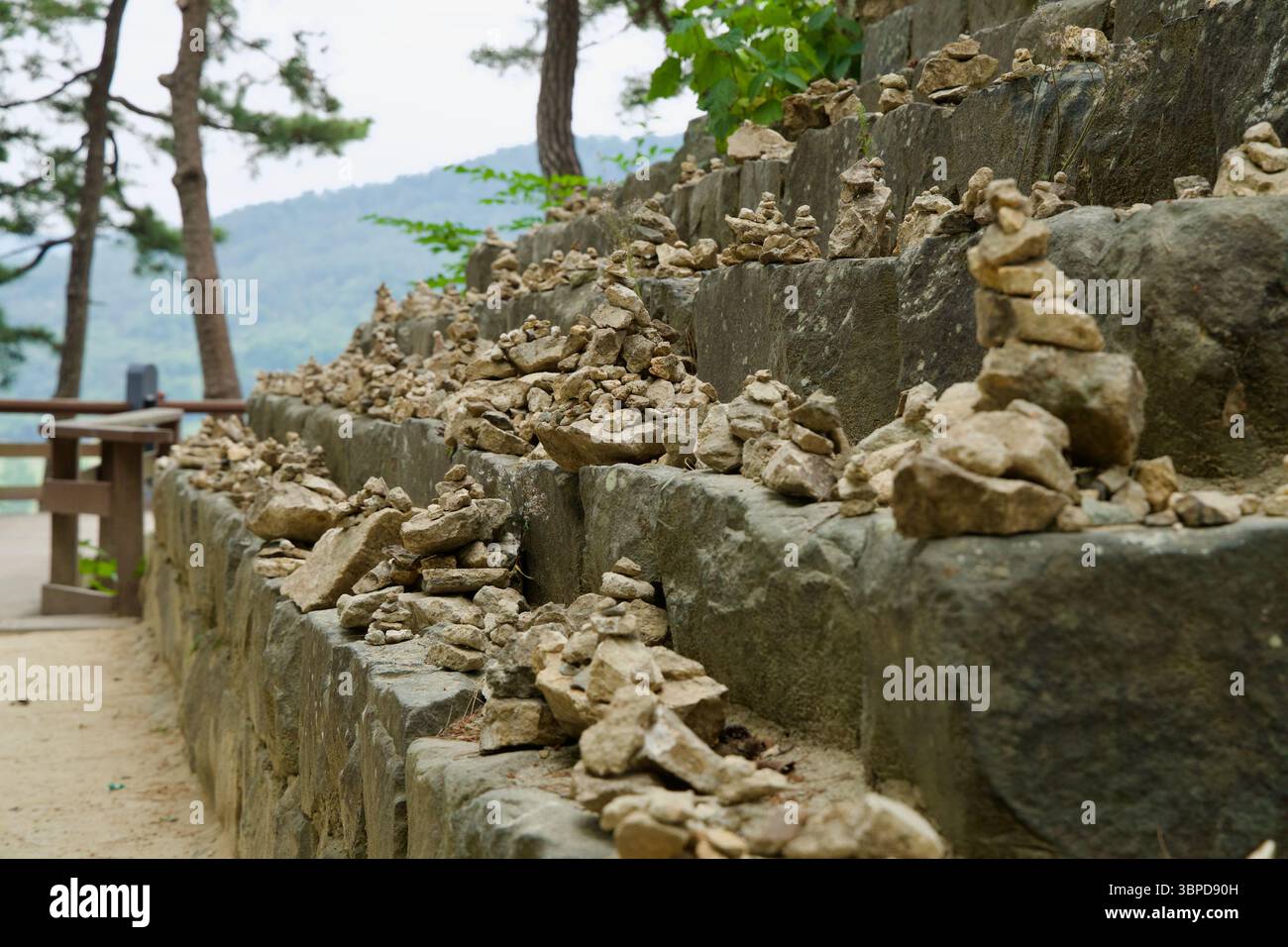 Contea di Buyeo, Corea del Sud - 13 giugno 2025: Piccoli mucchi di pietre sono impilati con cura lungo gli antichi gradini della roccia di Nakwaam, simboleggiando i desideri e i desideri Foto Stock