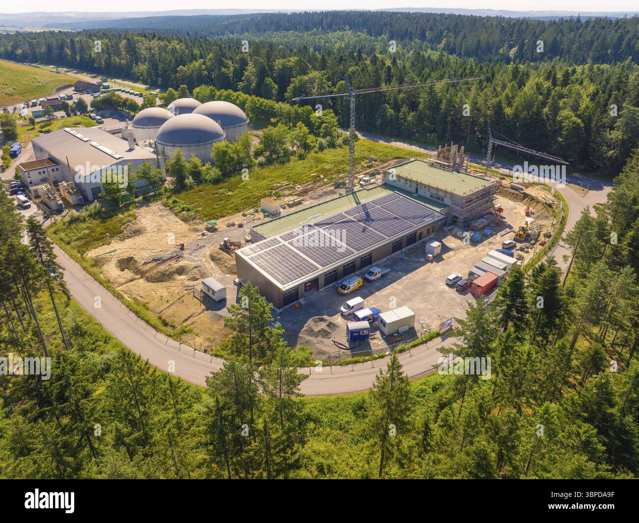 Immersa in un paesaggio boschivo, l'immagine mostra i sistemi solari sugli edifici di un cantiere edile, nuova stazione dei vigili del fuoco, Oberhaugstett, distretto di Calw, G. Foto Stock