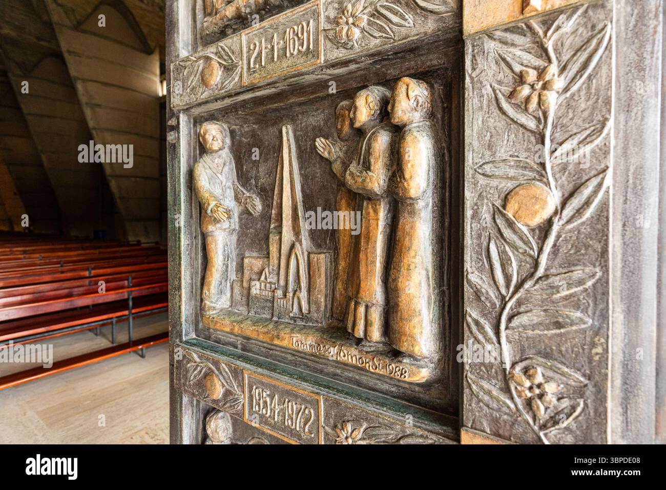 Dettagliata scultura in rilievo religioso sulla porta della cattedrale, raffigurante figure bibliche o storiche in preghiera Foto Stock