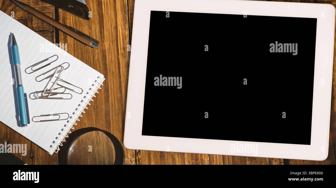 L'area di lavoro della scrivania sopraelevata presenta strumenti di design piatto, con tablet, penna per notebook e lente di ingrandimento Foto Stock