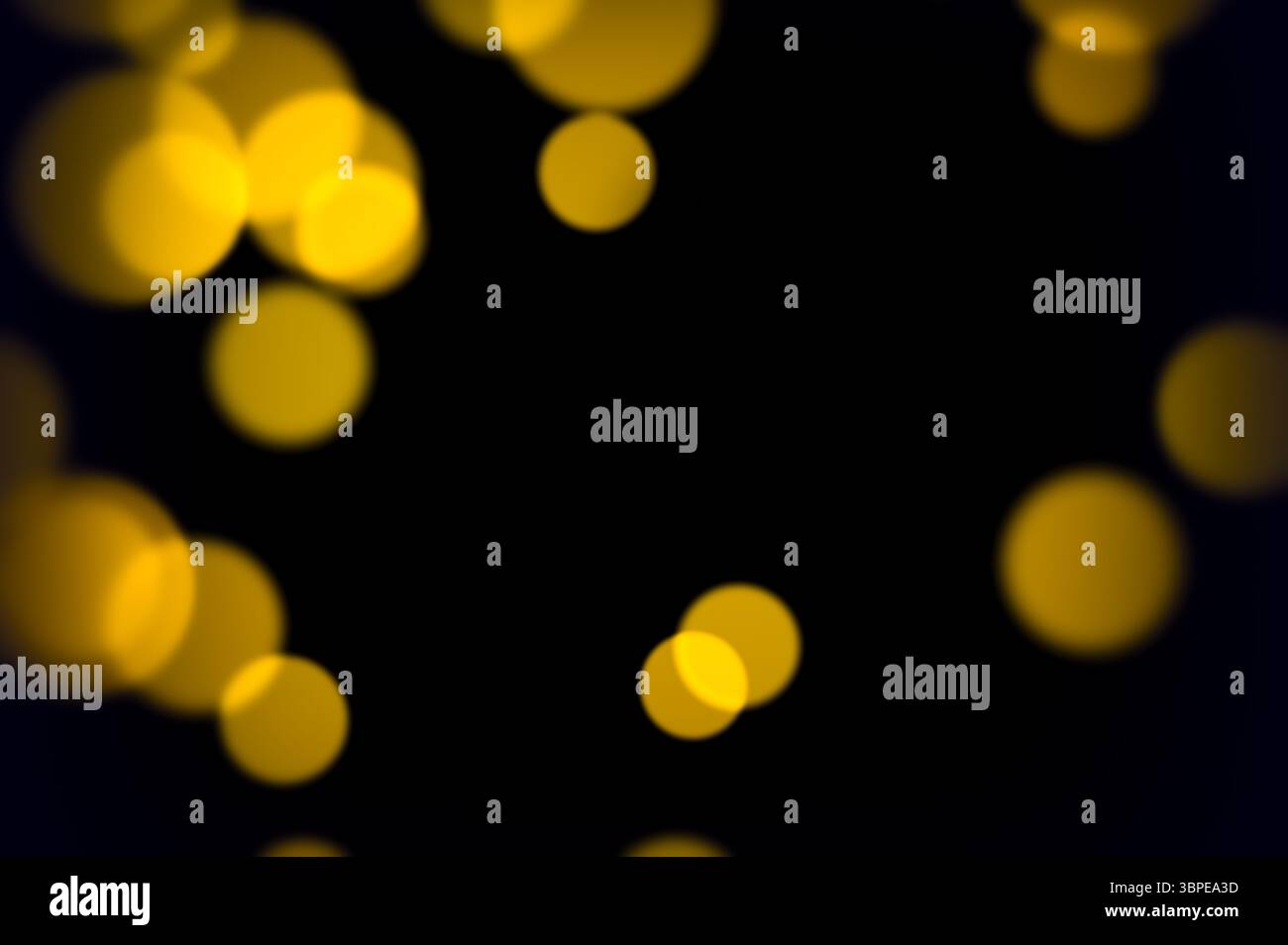 I cerchi gialli dorati fluttuano dolcemente sulla scena scura con un soffice effetto bagliore, ideali per le feste di nozze o per composizioni a tema caldo Foto Stock