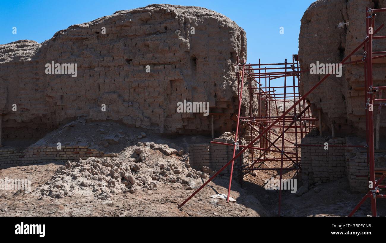 I lavoratori si impegnano in attività di scavo e restauro presso il sito archeologico di Kish in Iraq, concentrandosi su antiche rovine e strutture. Foto Stock
