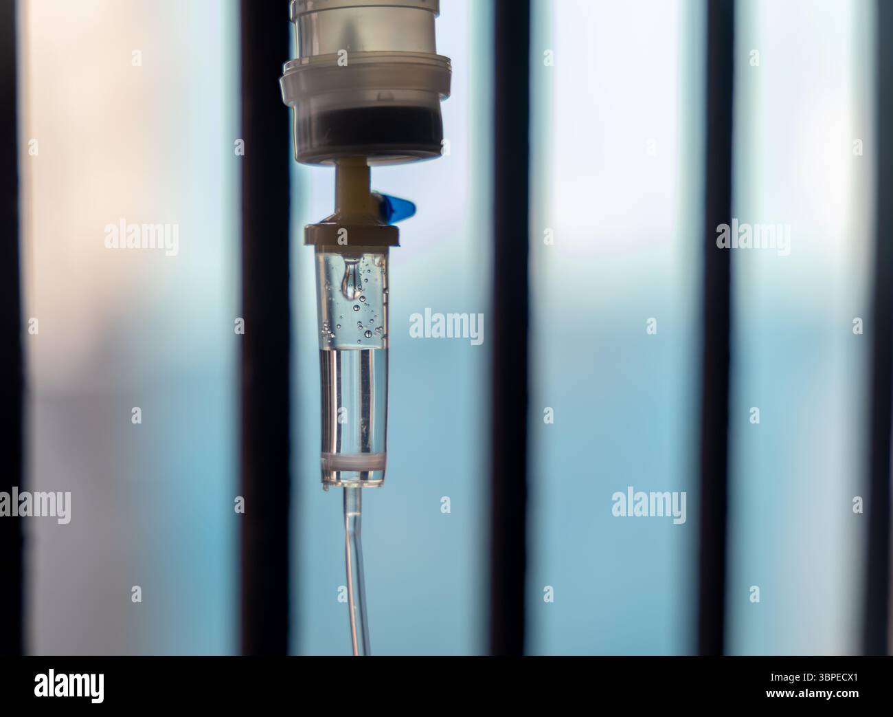 goccioline di gocciolamento iv che fluiscono nel tubo vicino alla finestra dell'ospedale Foto Stock