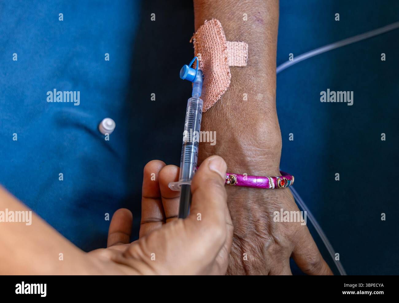 iniezione cannula completa inserita nella mano del paziente durante il giorno in ambienti chiusi Foto Stock