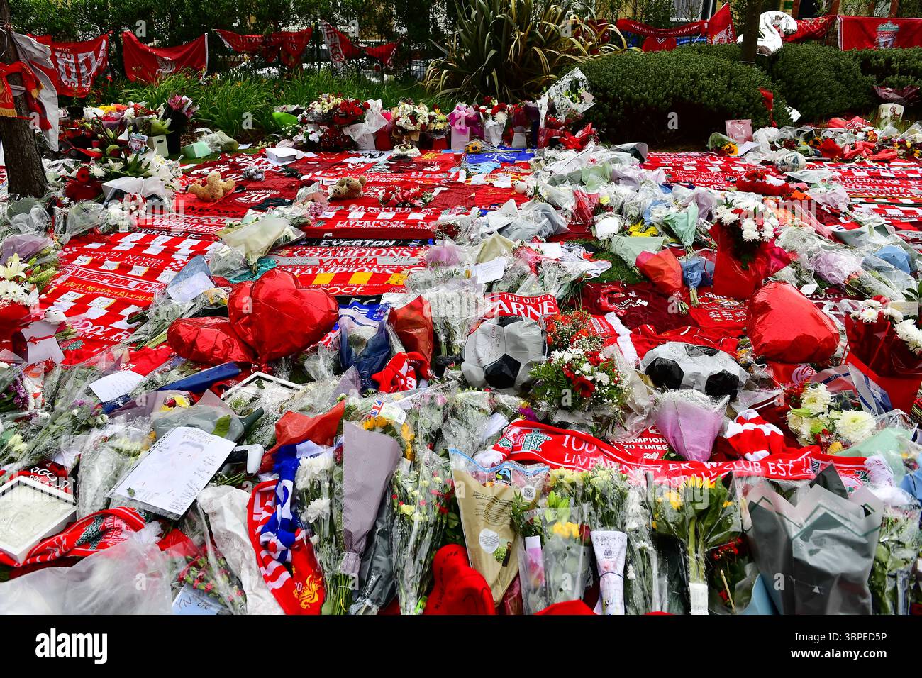 Tributi floreali, sciarpe, palloncini, messaggi di condoglianze ecc. sono collocati fuori dal Liverpool Football Club in memoria di Diogo Jota ucciso in RTA. Foto Stock