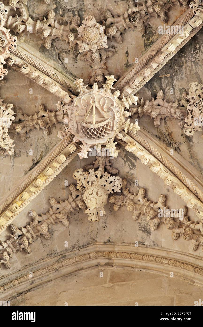 Intricati lavori in pietra ed elementi gotici nel soffitto del monastero di Batalha. Foto Stock