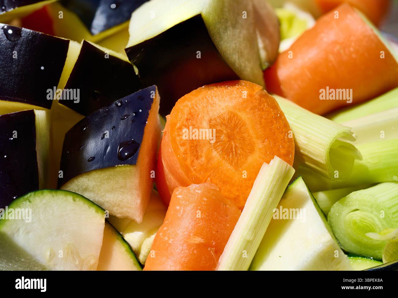 Colorato mix di carote tritate, zucchine, melanzane e sedano, creando una base vibrante e sana per varie creazioni culinarie Foto Stock