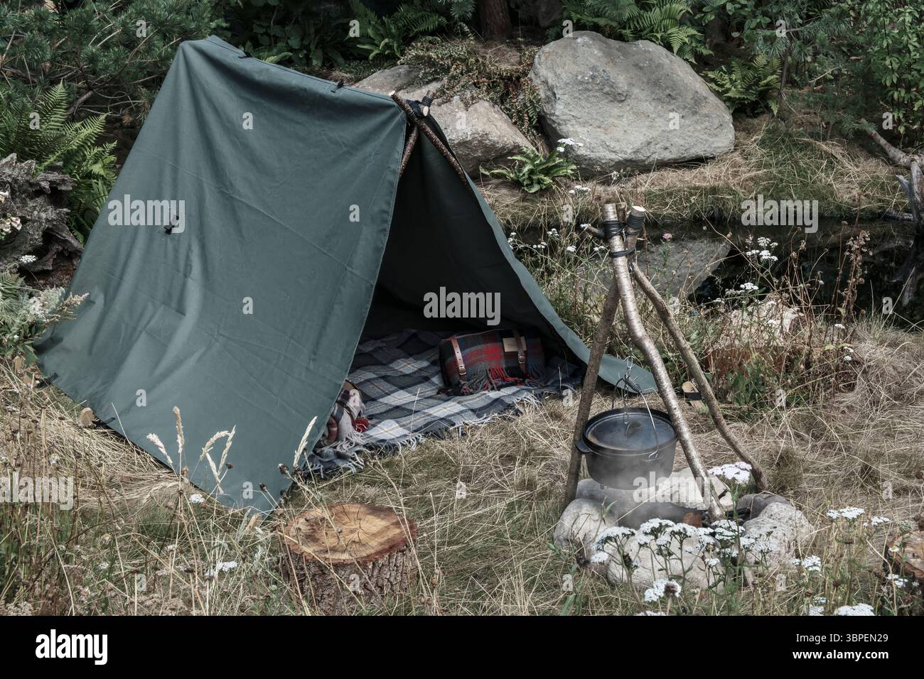 Richmond-upon-Thames, Londra - Una piccola tenda e un fuoco da campo costituiscono una piccola mostra all'Hampton Court Flower Show. Foto Stock