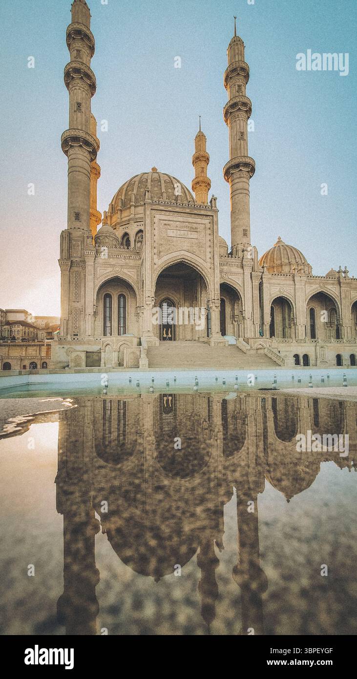 La Moschea Heydar di Baku, Azerbaigian, è stata catturata durante l'ora d'oro con i suoi quattro minareti torreggianti e le intricate pietre che si riflettono magnificamente sul Foto Stock