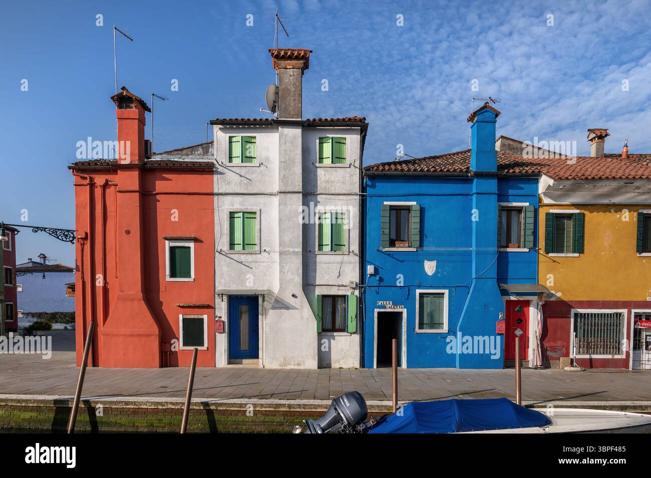 Case tradizionali di charme con camini che sporgono dalle facciate dell'isola di Burano nella laguna di Venezia in Italia. Foto Stock