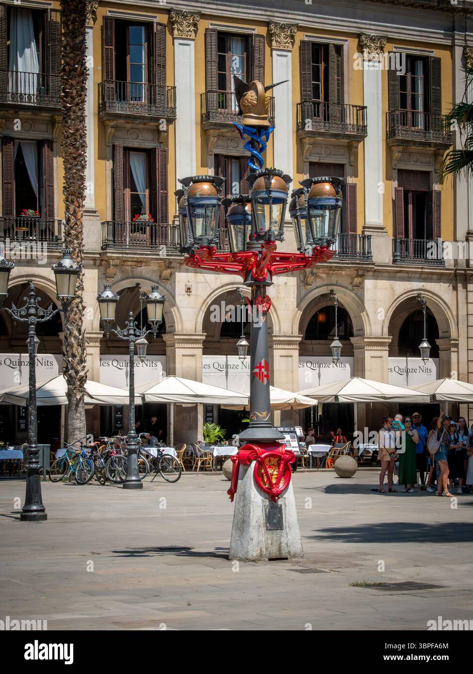 Un lampione decorato progettato da Antoni Gaudí si trova nel centro di Plaza Reial, una piazza popolare e storica di Barcellona, Spagna. Foto Stock