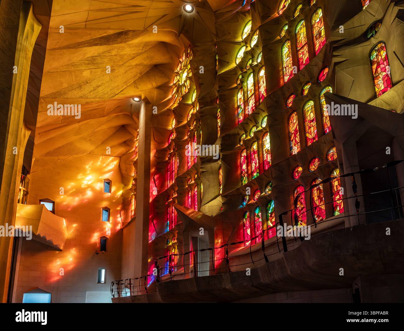 La luce del sole scorre attraverso le colorate vetrate colorate, creando splendidi effetti luminosi all'interno della Sagrada Familia, Barcellona, Spagna. Foto Stock