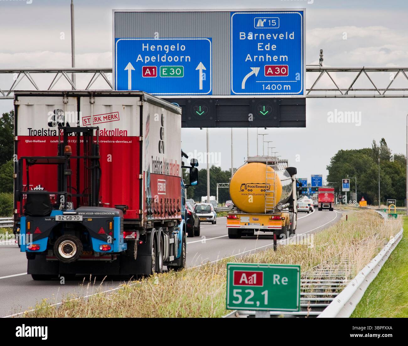 Le indicazioni stradali per i Paesi Bassi indicano la direzione e la distanza fino alla prima uscita. Il cartello verde di fronte è un segnale di distanza posto ogni 10 Foto Stock