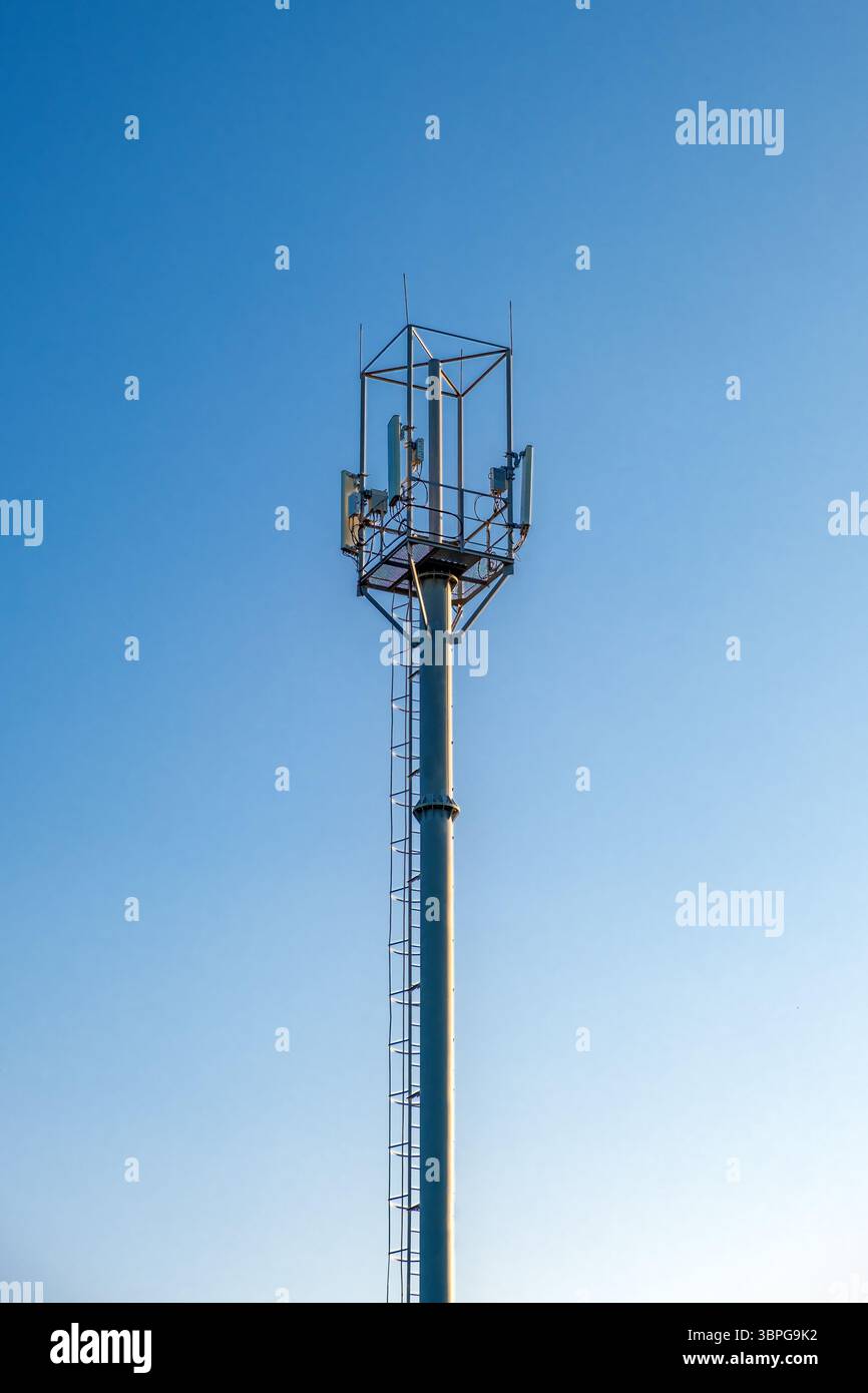 telefono cellulare e torre di connessione wireless sullo sfondo del cielo Foto Stock