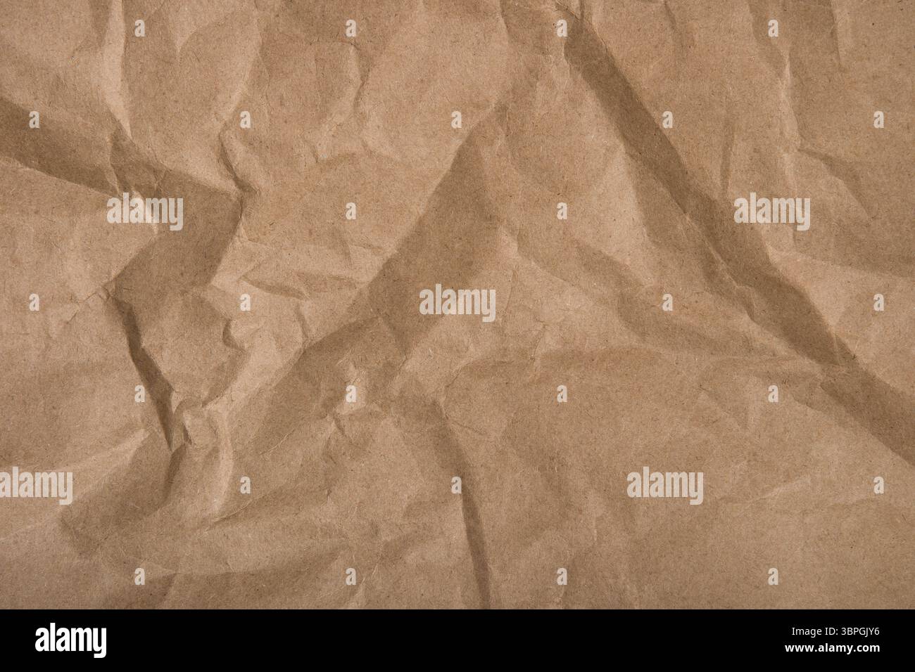 Sfondo carta astratta. Carta kraft avvolta con una trama tritata. Sfondo per la progettazione con uno spazio di copia. Concetto di utilizzo di materiali riciclati Foto Stock