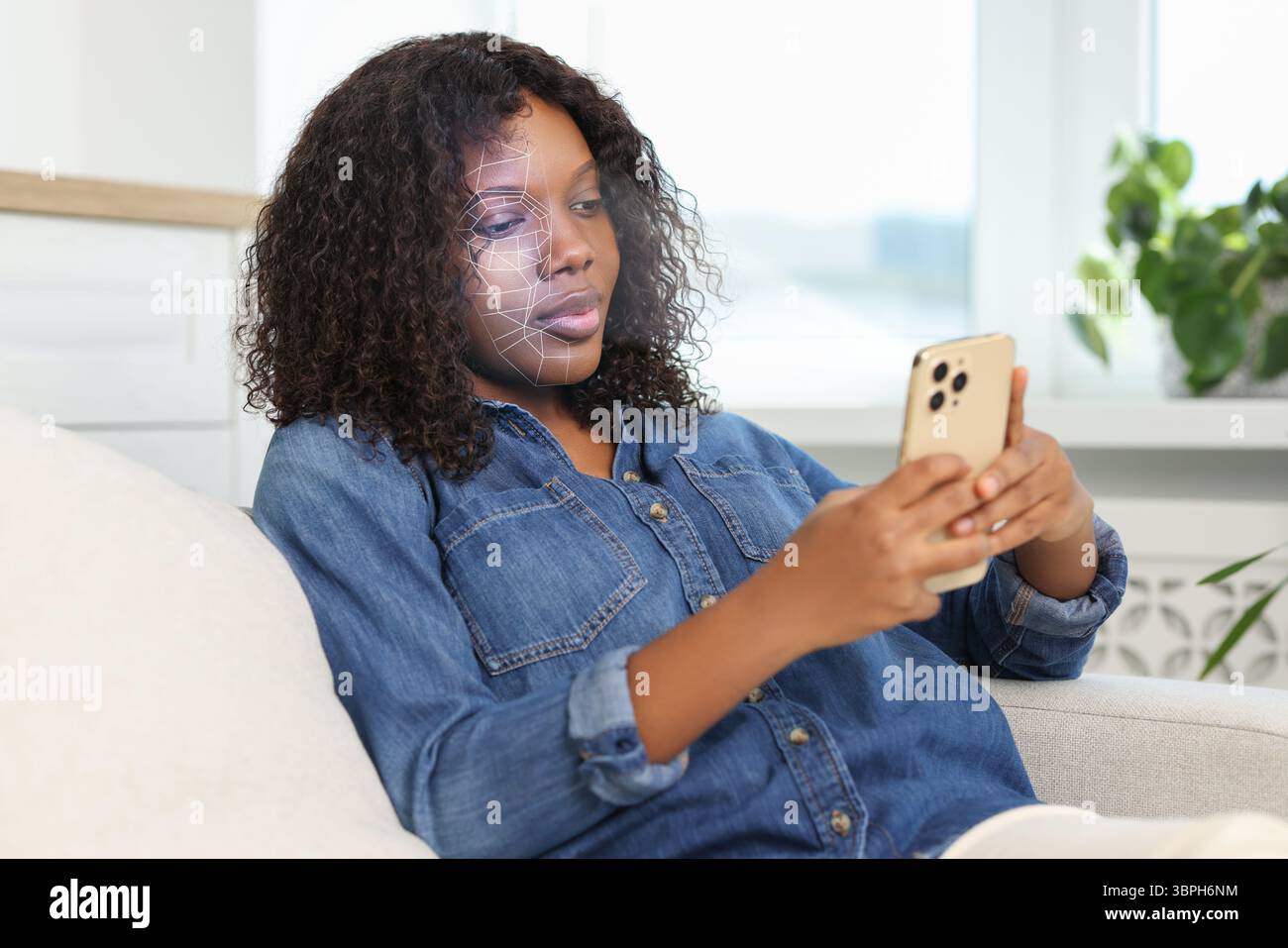 Donna che sblocca il suo smartphone con l'app di riconoscimento facciale a casa. Verifica biometrica Foto Stock