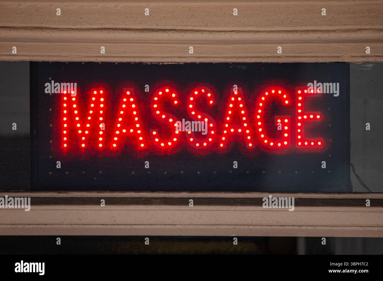 Primo piano di un cartello rosso al neon MASSAGGIO. Foto Stock
