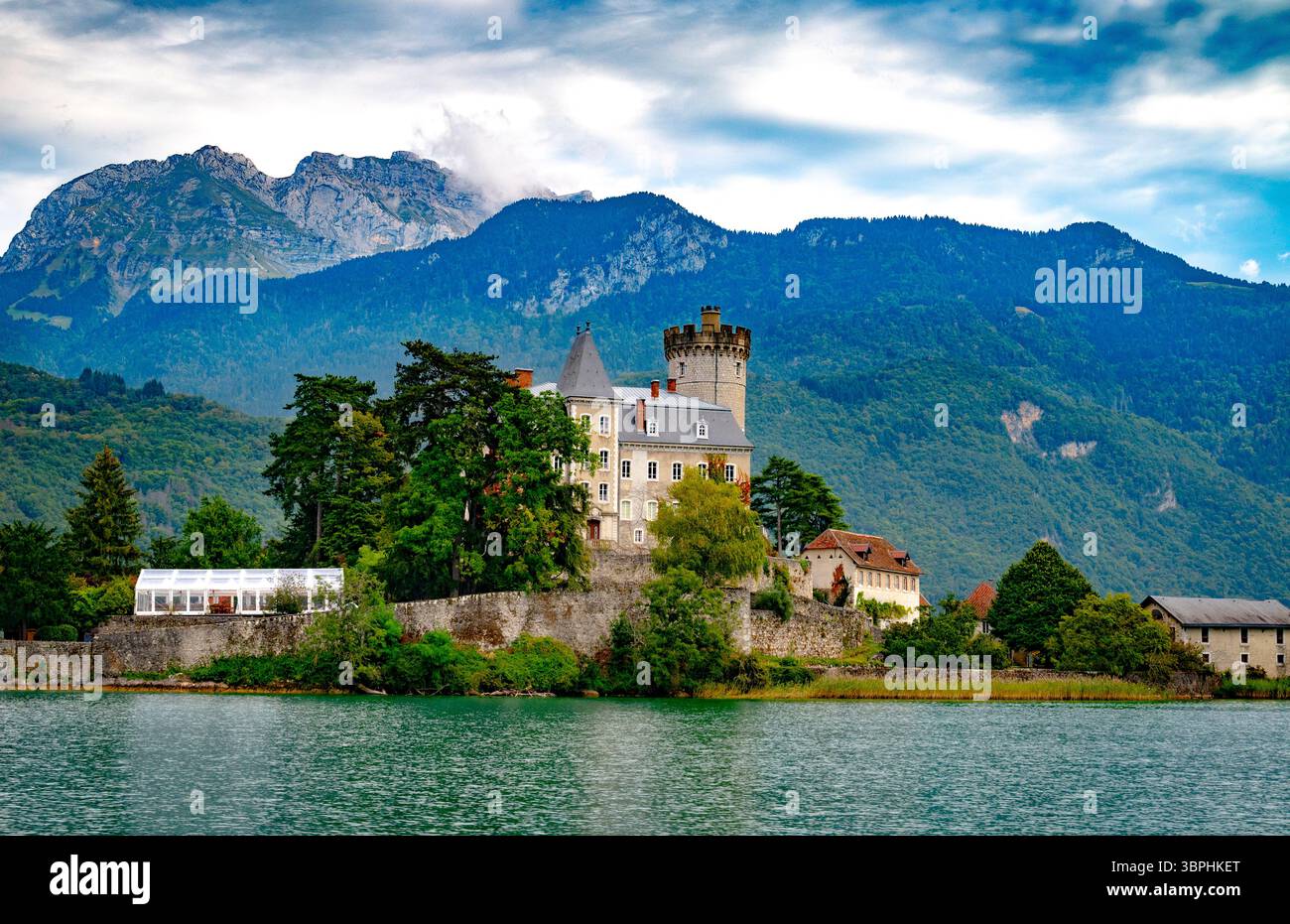Il maestoso Chateau de Duingt si affaccia sulle case, le chiese e gli hotel del Lago di Annecy, con foreste miste sulle rive del Lago di Annecy in Francia Foto Stock