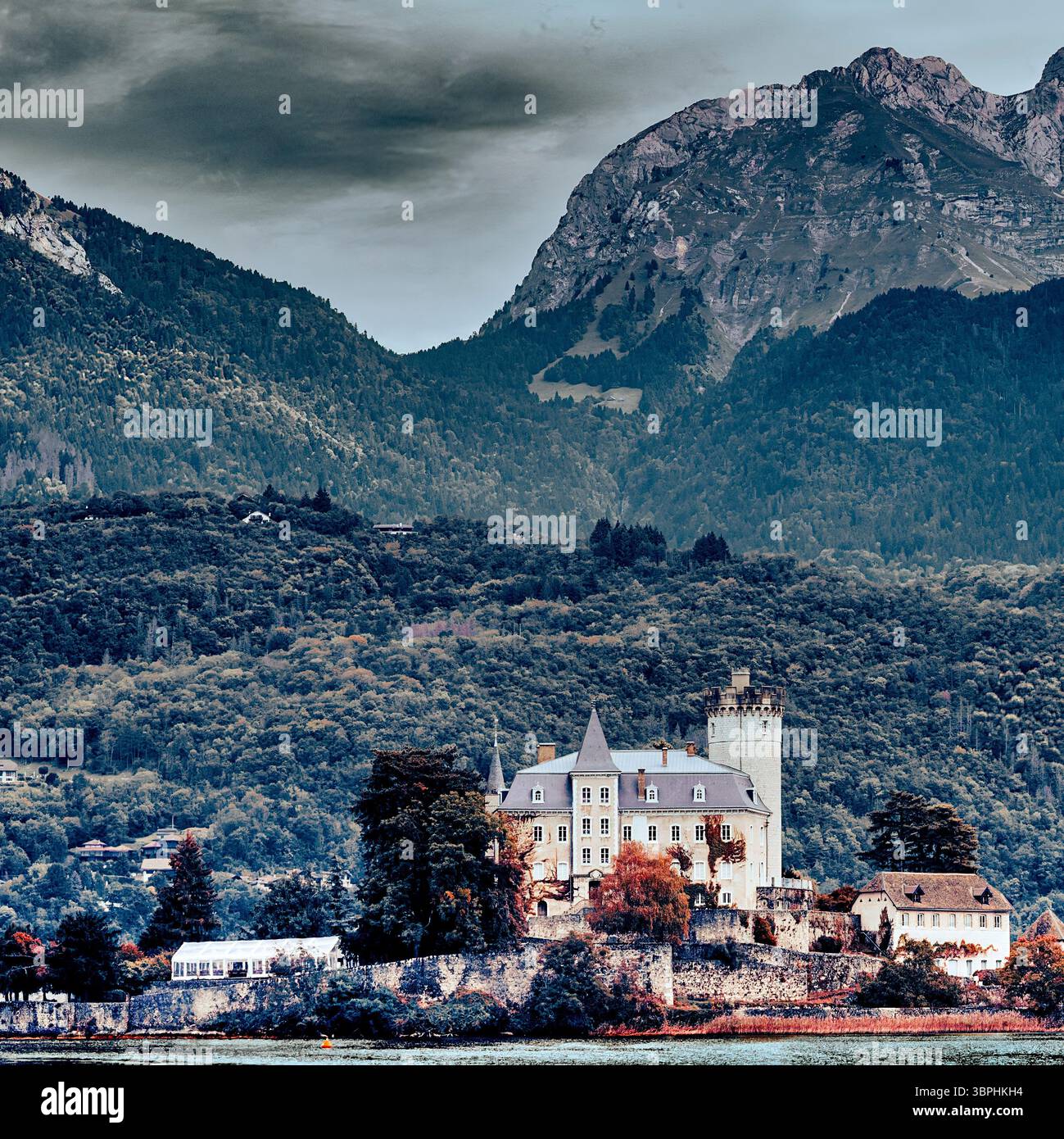 Il maestoso Chateau de Duingt si affaccia sulle case, le chiese e gli hotel del Lago di Annecy, con foreste miste sulle rive del Lago di Annecy in Francia Foto Stock