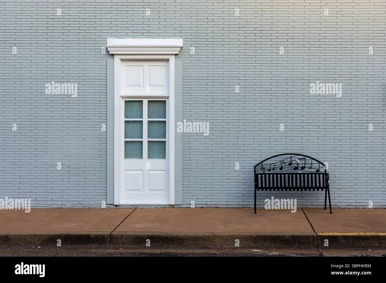 Street Scene minimalista con porta e panca musicale Foto Stock