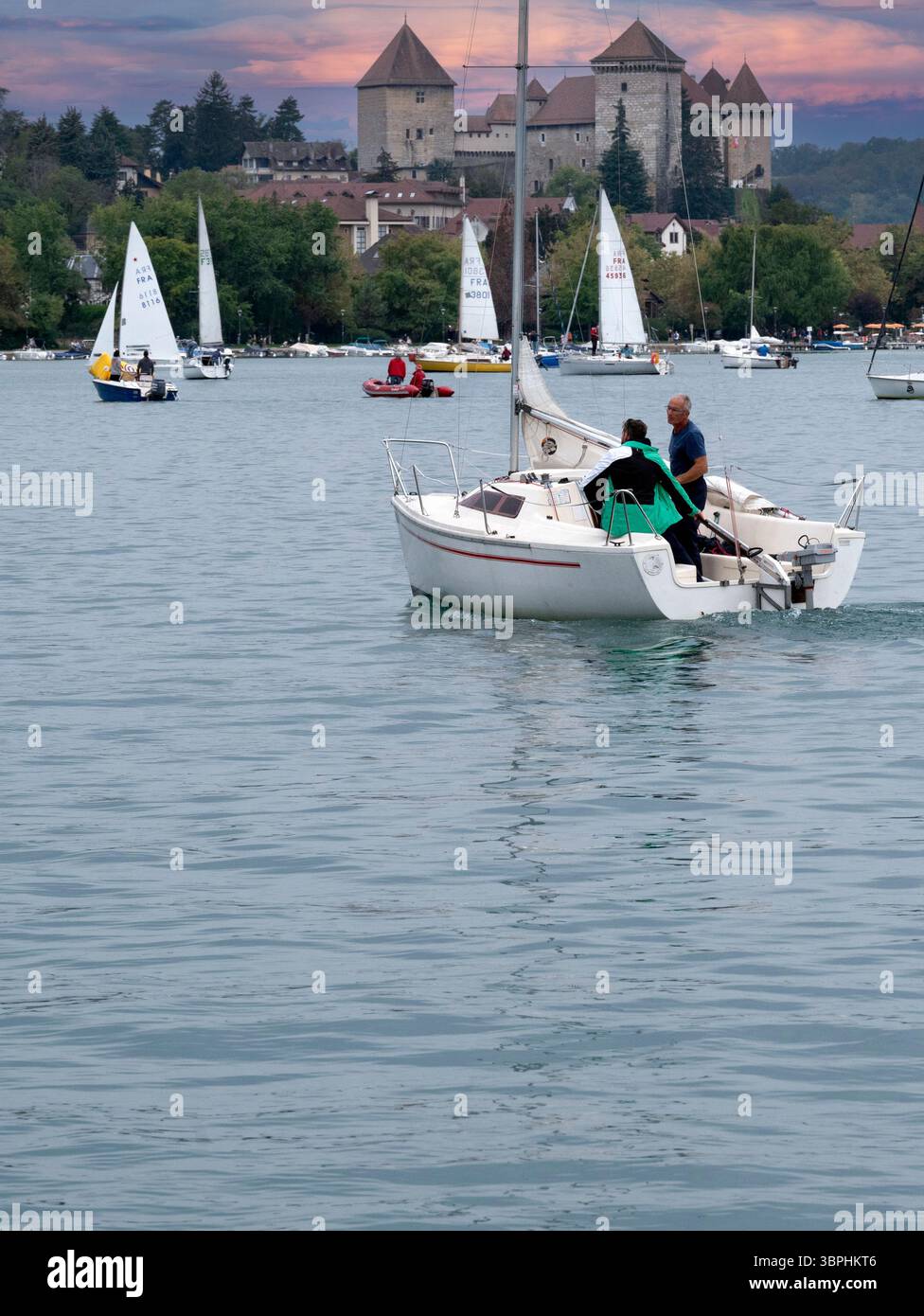 Le barche a vela sono molto popolari sul lago di Annecy nelle Alpi francesi, lo storico castello d'Annecy si affaccia sulla città e sulla foresta alpina circostante, Annecy, Foto Stock