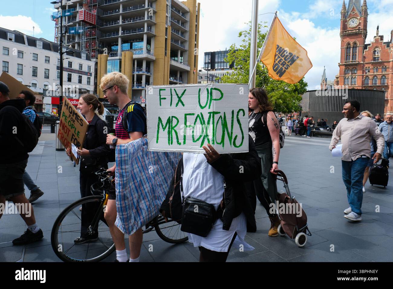 Londra, Regno Unito. 7 luglio 2025. London Renters Union protesta contro Notting Hill Genesis - il manifestante tiene un cartello fuori dalla stazione di Kings Cross Foto Stock