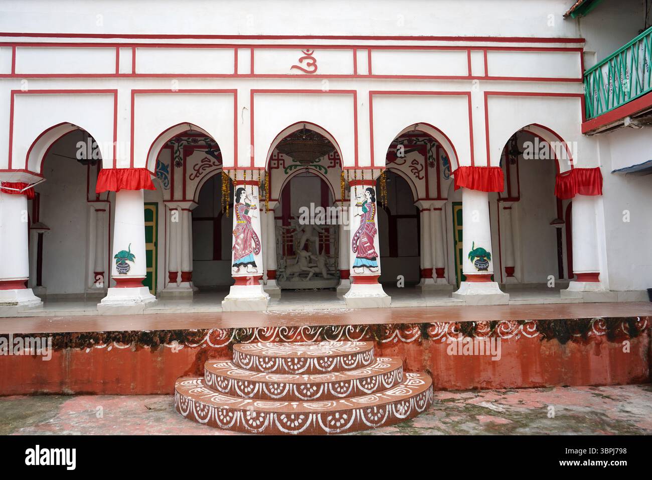 Cortile decorato di un tradizionale Bonedi bengalese Bari con motivi folcloristici e archi rosso-bianco al Mejo Bari Behala Kolkata Foto Stock
