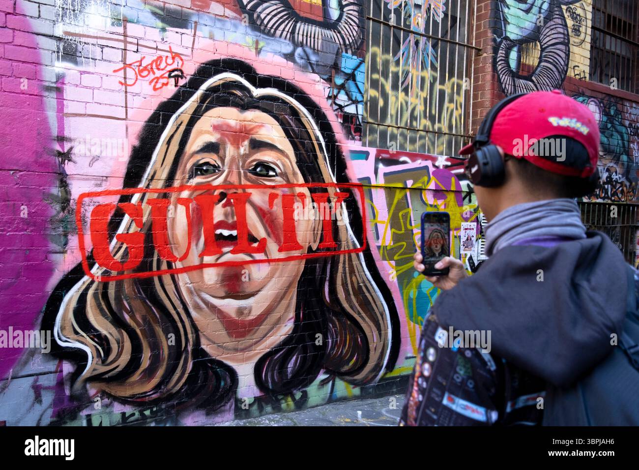 Fotografare un murale di graffiti di Erin Patterson, l'assassino dei funghi, con la parola colpevole dipinta sul viso. Melbourne, Victoria, Australia. Foto Stock