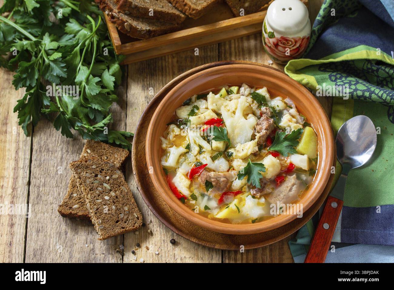 Zuppa tradizionale ungherese spessa con manzo, verdure e gnocchi su un tavolo di legno. Cena o pranzo caldi Foto Stock