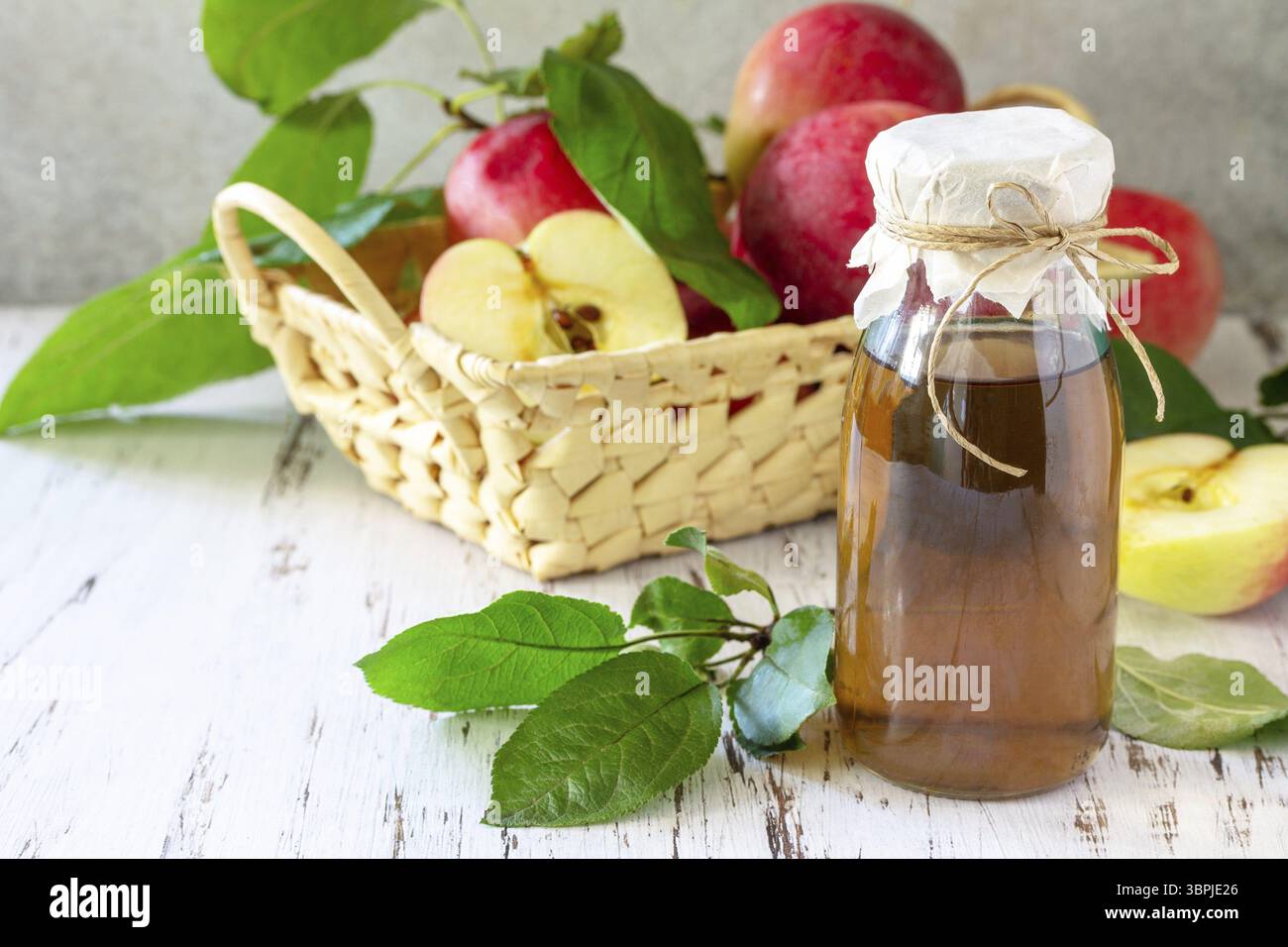 Cibo biologico sano. Aceto di mele, una bottiglia di aceto di sidro di mele su un tavolo rustico Foto Stock